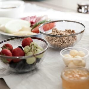 A delicious and nutritious breakfast spread featuring fresh fruits, granola, and juice on a dining table.